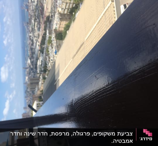 מעקה עץ צבוע בלכה כהה ומבריקה במרפסת